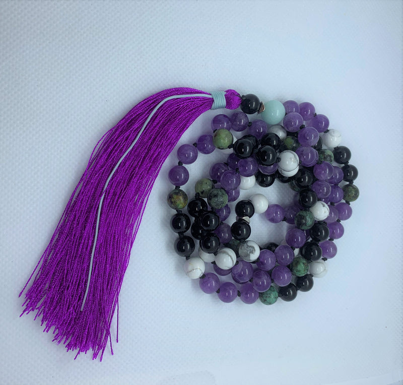 "Mynd-Happiness" is a Stunning and Colorful 108 hand-made mala necklace that features Amethyst and African Turquoise with purple Tassel.