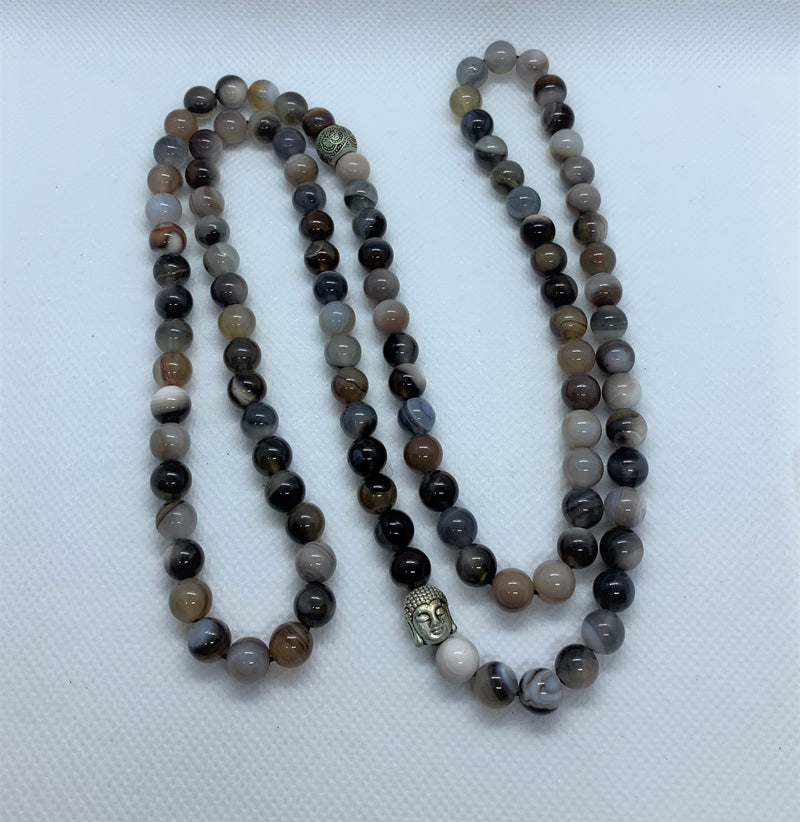 "Mynd-Prosperity" is an Elegant 108 hand-made necklace that features Lace Agate with Buddha as signature beads with no tassel, perfecto be worn as a bracelet.