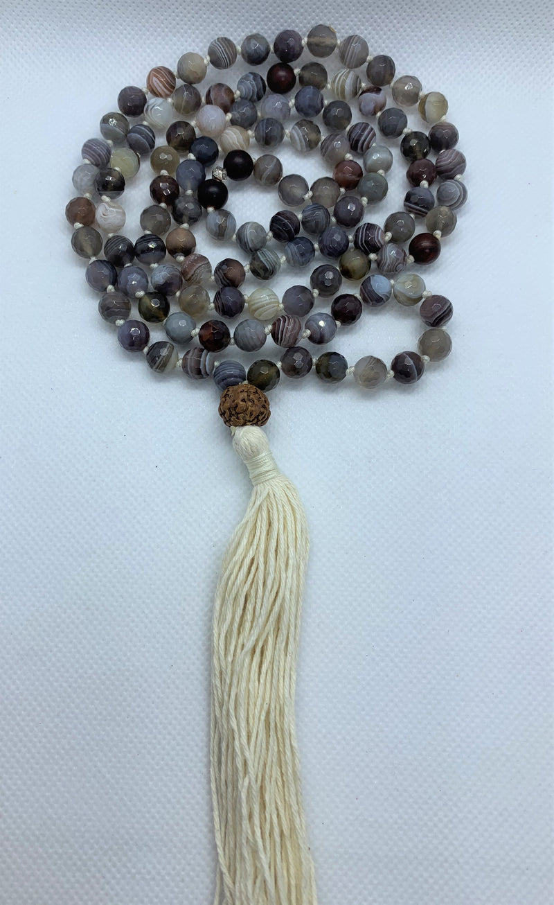 “Mynd-Light” This exclusive 108 hand-made mala beads necklace features Crazy Lace Agate beads with beige tassel and a Rudraksha as the Gury bead.   Malas are used to count the number of times a mantra is recited while meditating or praying. It comes with 108 beads, while you wear your mala throughout the day it serves as a constant reminder of your intentions and enhances your style. 