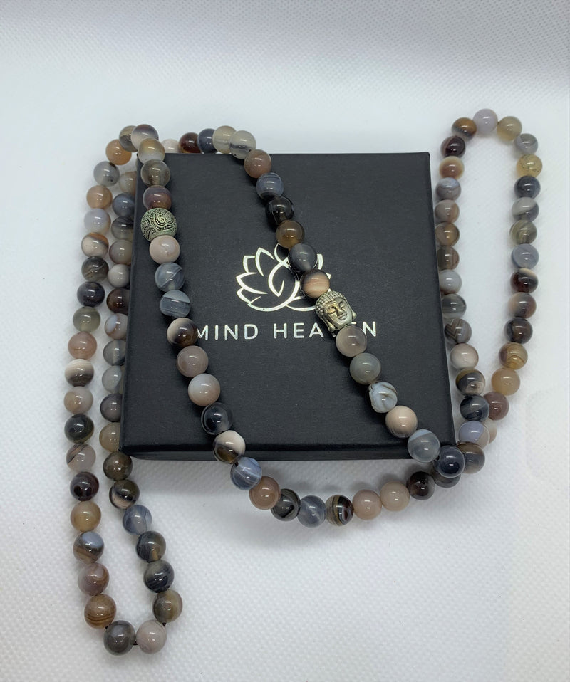 "Mynd-Prosperity" is an Elegant 108 hand-made necklace that features Lace Agate with Buddha as signature beads with no tassel, perfecto be worn as a bracelet.