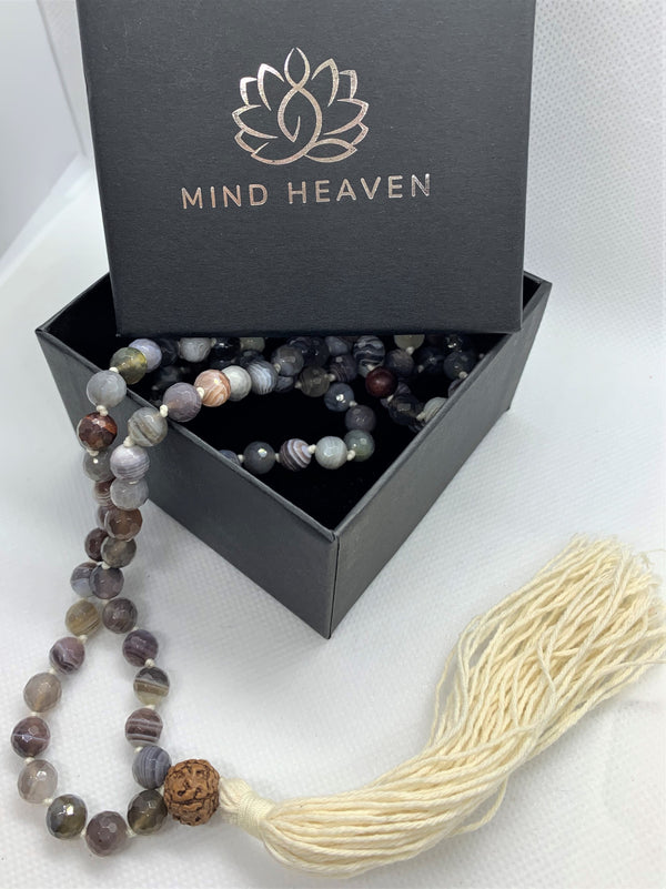 “Mynd-Light” This exclusive 108 hand-made mala beads necklace features Crazy Lace Agate beads with beige tassel and a Rudraksha as the Gury bead.   Malas are used to count the number of times a mantra is recited while meditating or praying. It comes with 108 beads, while you wear your mala throughout the day it serves as a constant reminder of your intentions and enhances your style. 