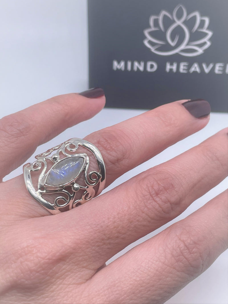The mysterious glow of this oval moonstone cabochon is beautifully presented in this textured and polished sterling silver ring. It will make a gorgeous statement with any ensemble. 1" wide. Moonstone scrollwork ring.
