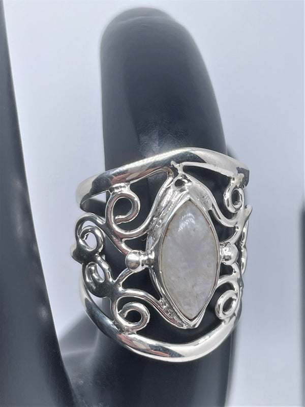 The mysterious glow of this oval moonstone cabochon is beautifully presented in this textured and polished sterling silver ring. It will make a gorgeous statement with any ensemble. 1" wide. Moonstone scrollwork ring.