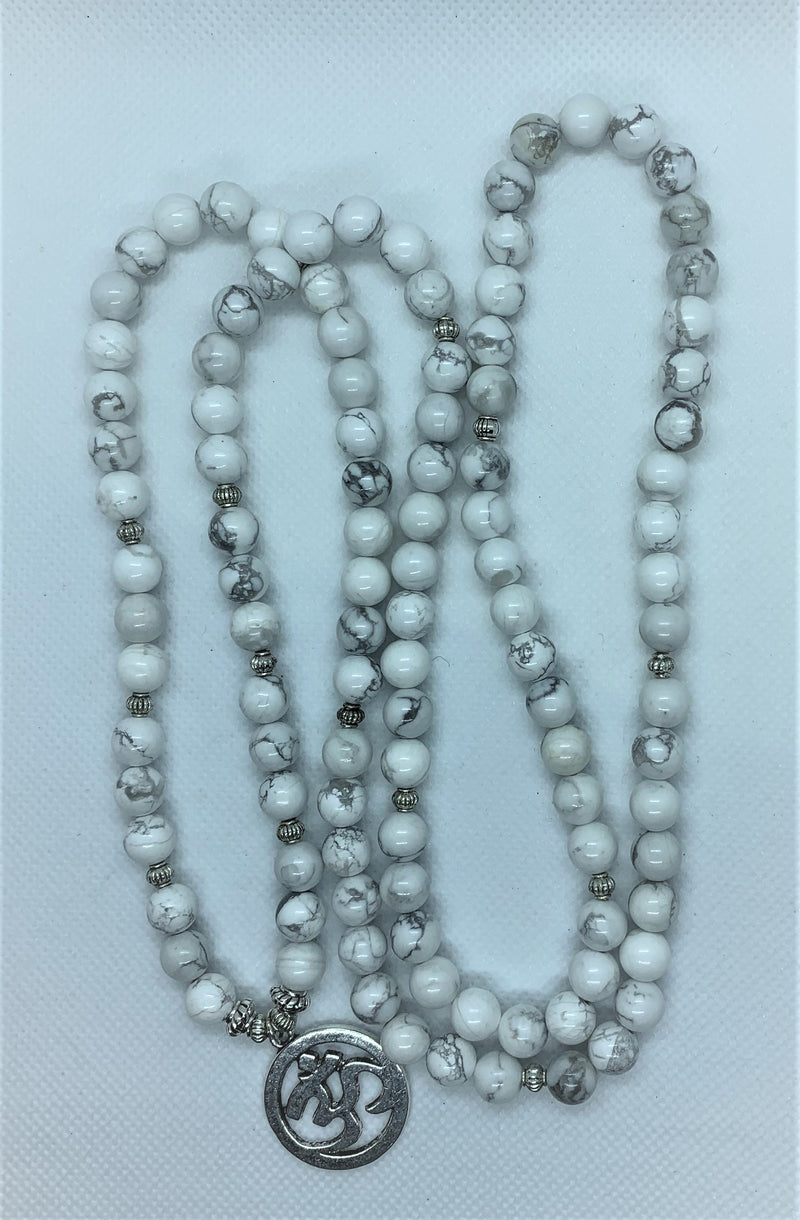 Howlite is often worn as a reminder of patience. The marbled stone is associated with inner calm, stress release, and soothing an overactive mind.   The Om symbol is the fundamental representation of the sound that originates from all living beings.
