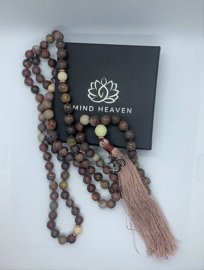 "Mynd-Kindness" is an exclusive 108 hand-made mala necklace that features Picasso Jasper stones with the Om symbol as a pendant.