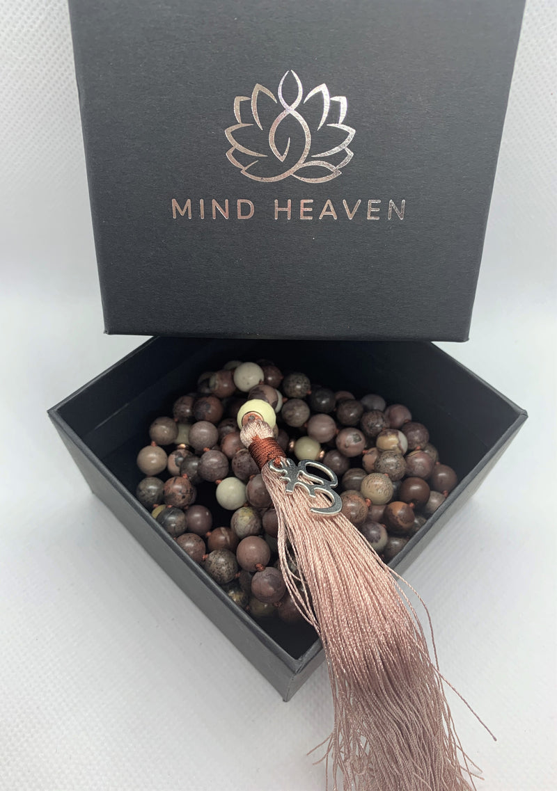 "Mynd-Kindness" is an exclusive 108 hand-made mala necklace that features Picasso Jasper stones with the Om symbol as a pendant.